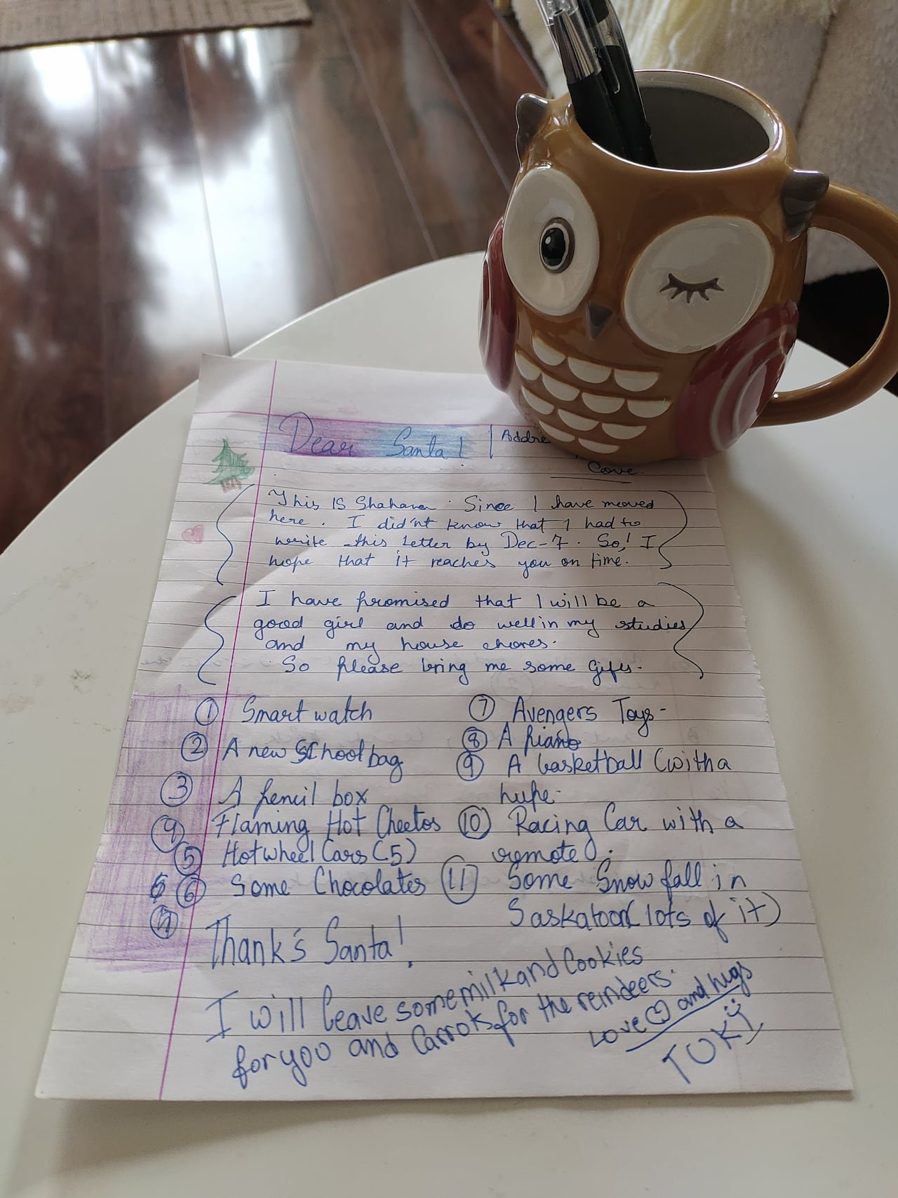default-354 A letter with handwriting sits on a table beside a coffee mug of a winking owl.